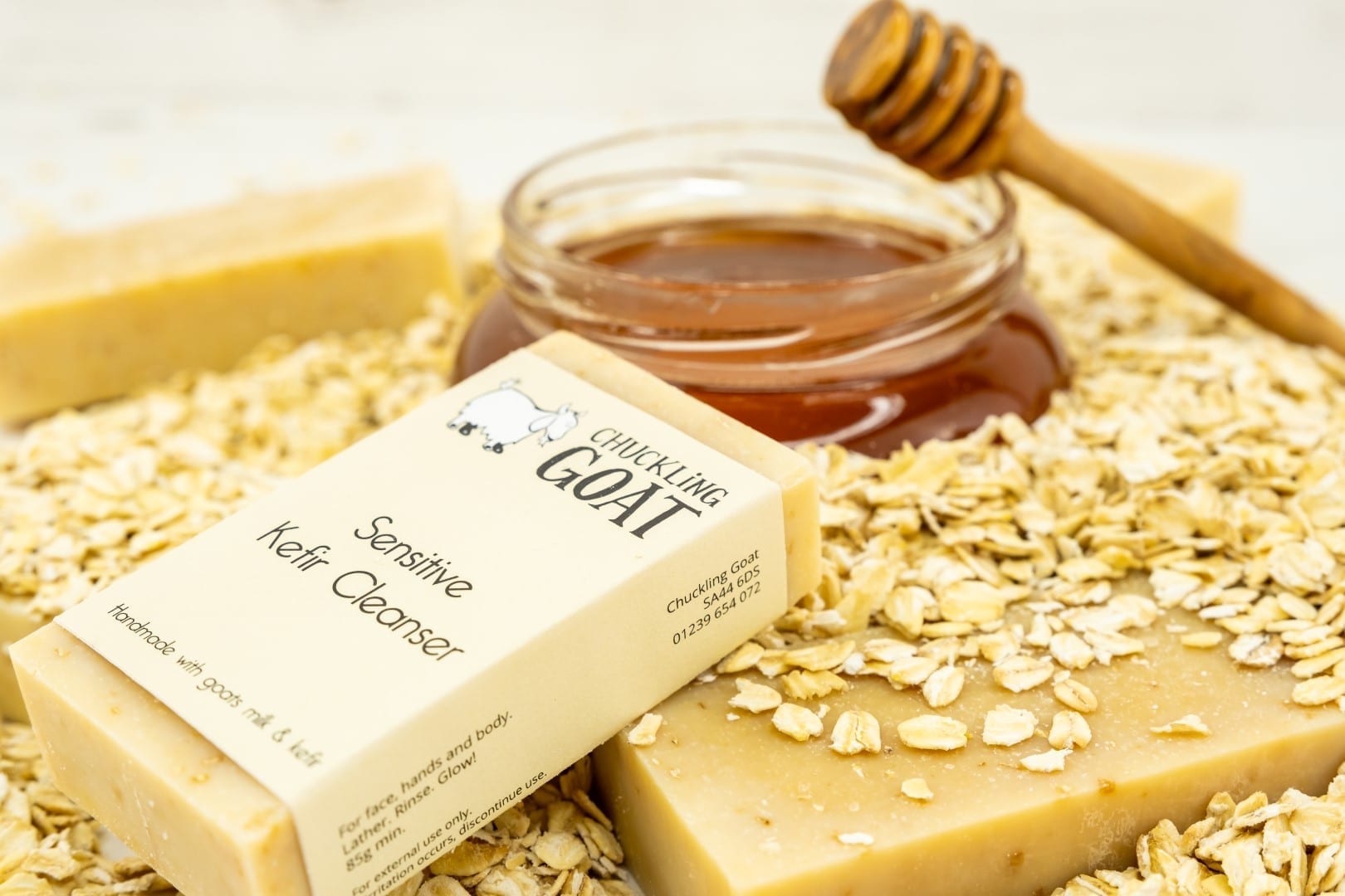 Bar of Chuckling Goat Sensitive Kefir Cleanser in front of honey oats and more bars