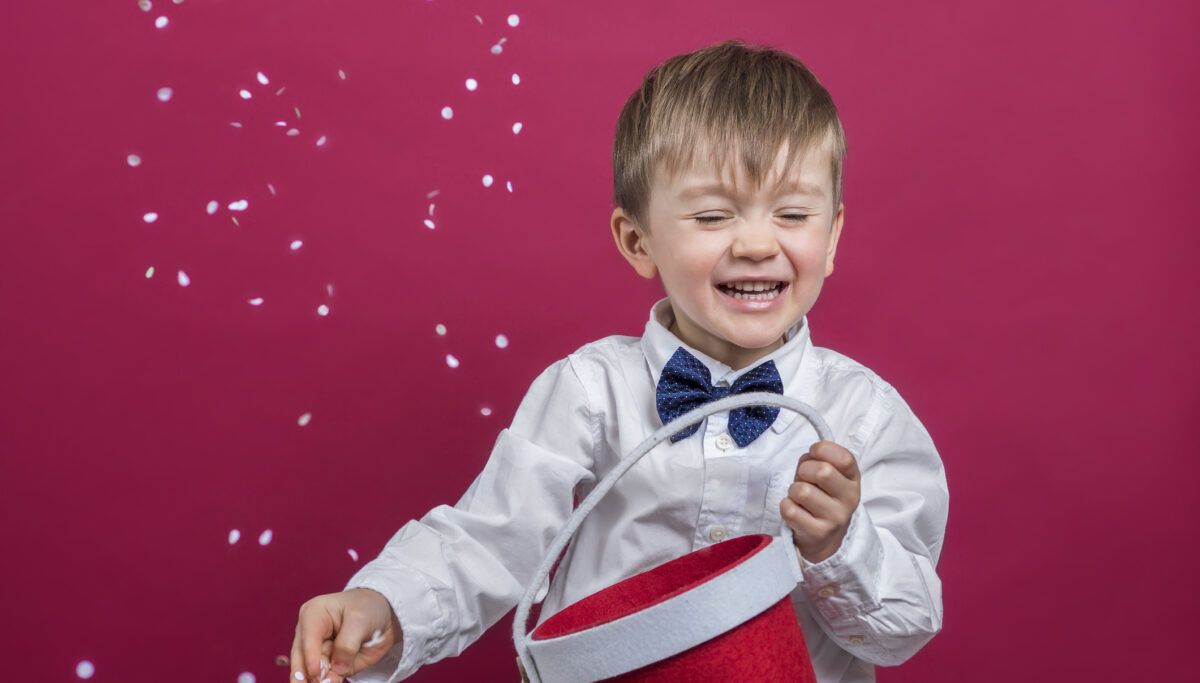 Cheerful kid throwing confetti