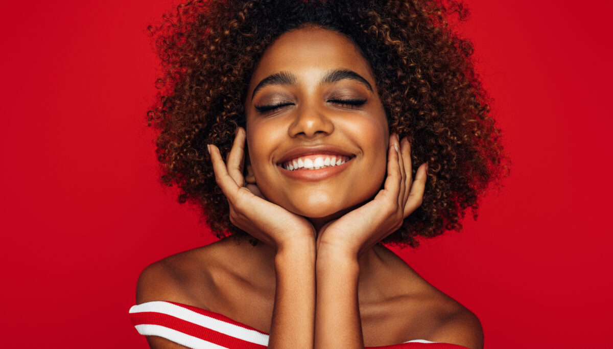 Smiling woman on red coloured background.