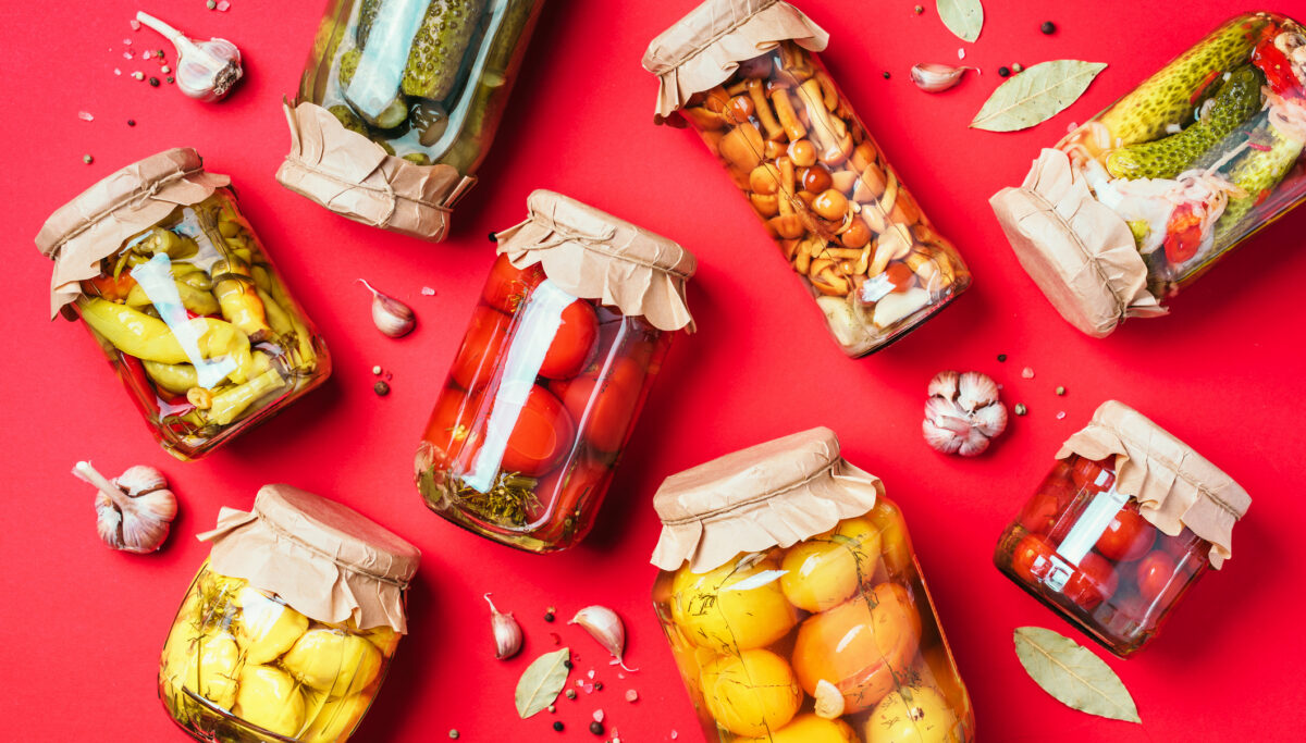 Healthy fermented food and pickles on red background