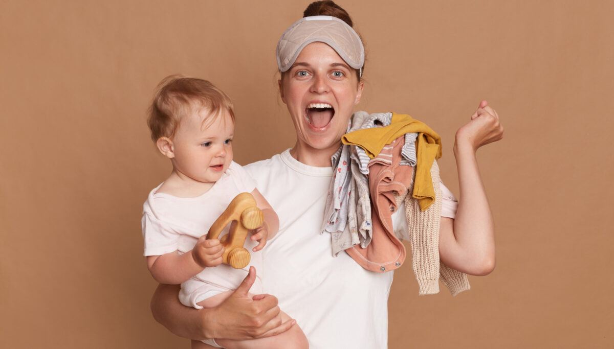 Joyful mother with baby, arms full, happy and busy Mother's Day