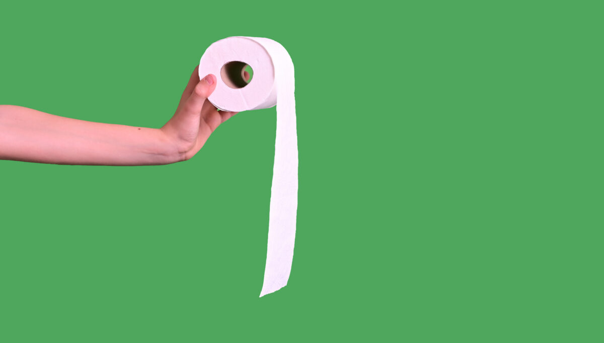 Minimalist hand holding toilet paper on green background, toilet habits concept