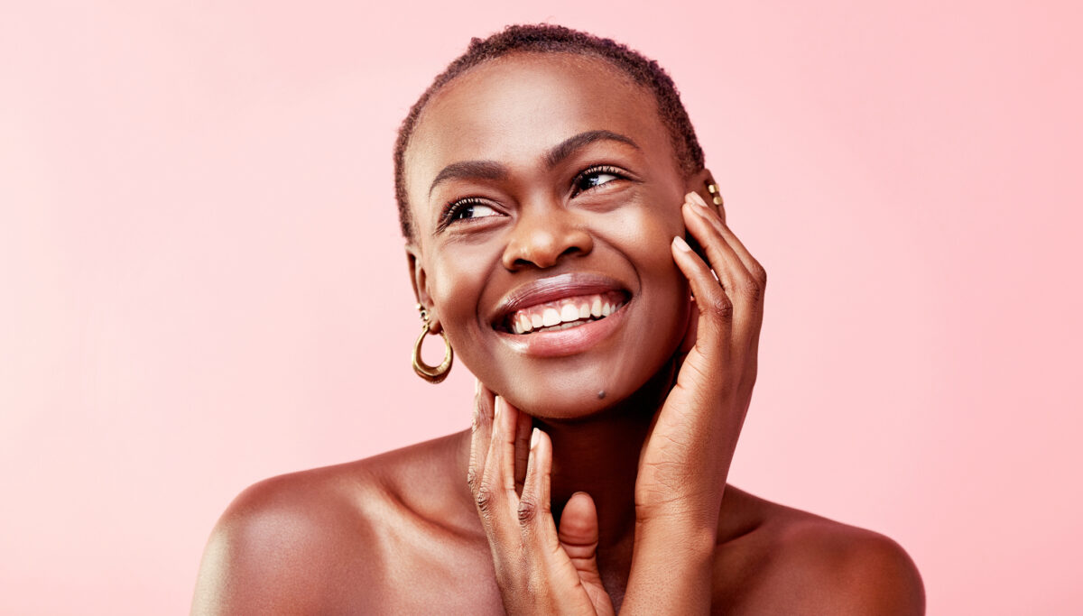 Young woman with glowing skin, pink background