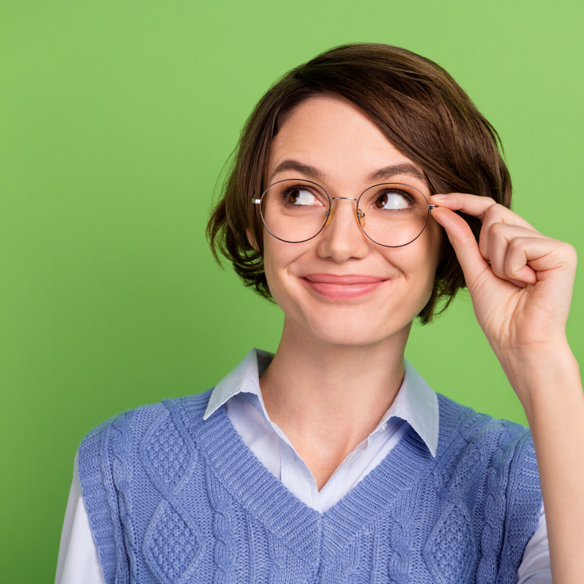 Photo portrait of clever woman in blue vest wearing glasses smiling looking copyspace isolated vibrant green color background