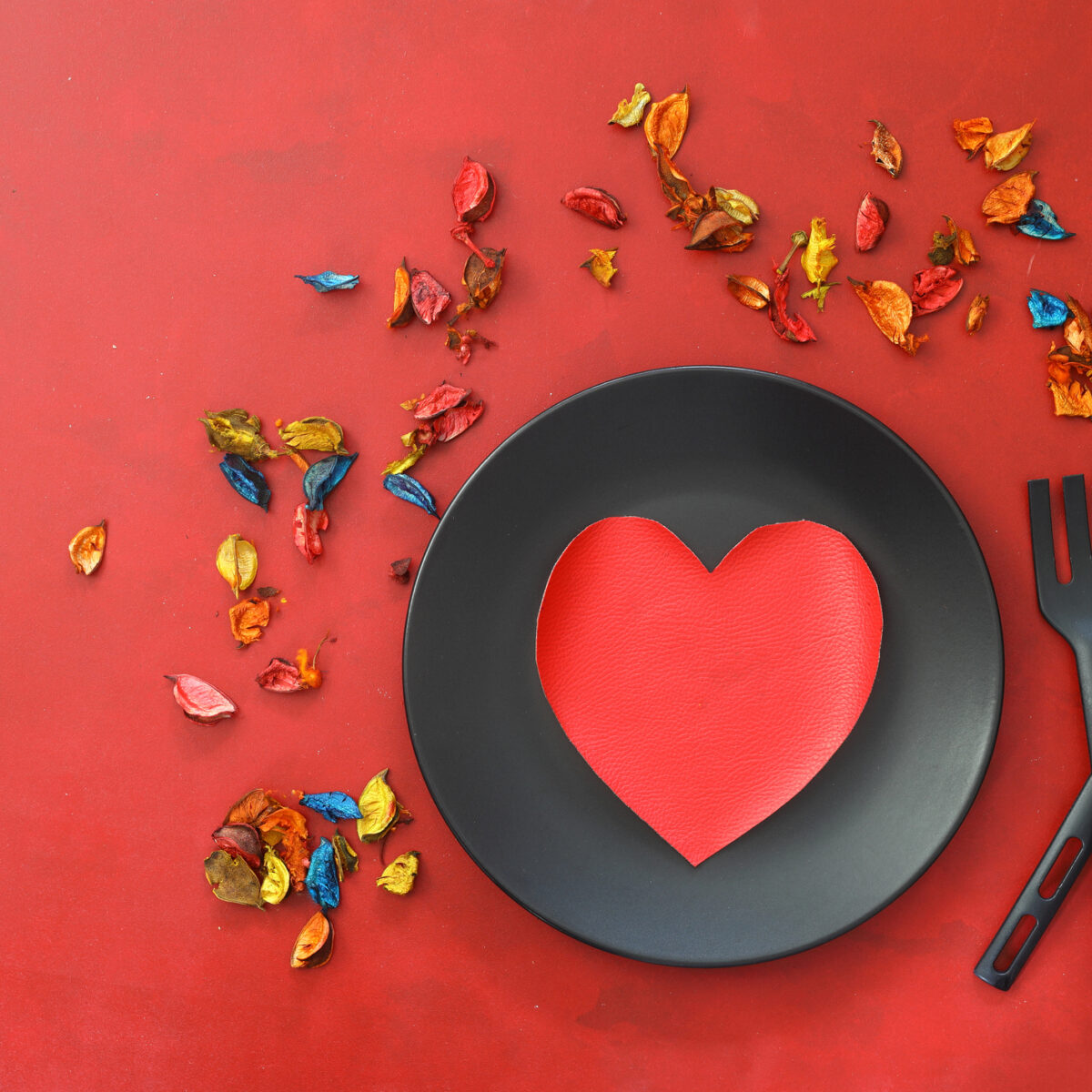 Kitchen cutlery on plate with gift and colorful rose. Love food, love yourself.