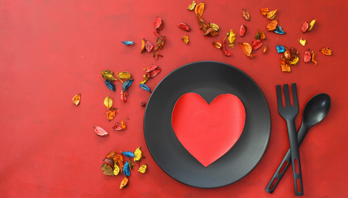 Kitchen cutlery on plate with gift and colorful rose. Love food, love yourself.