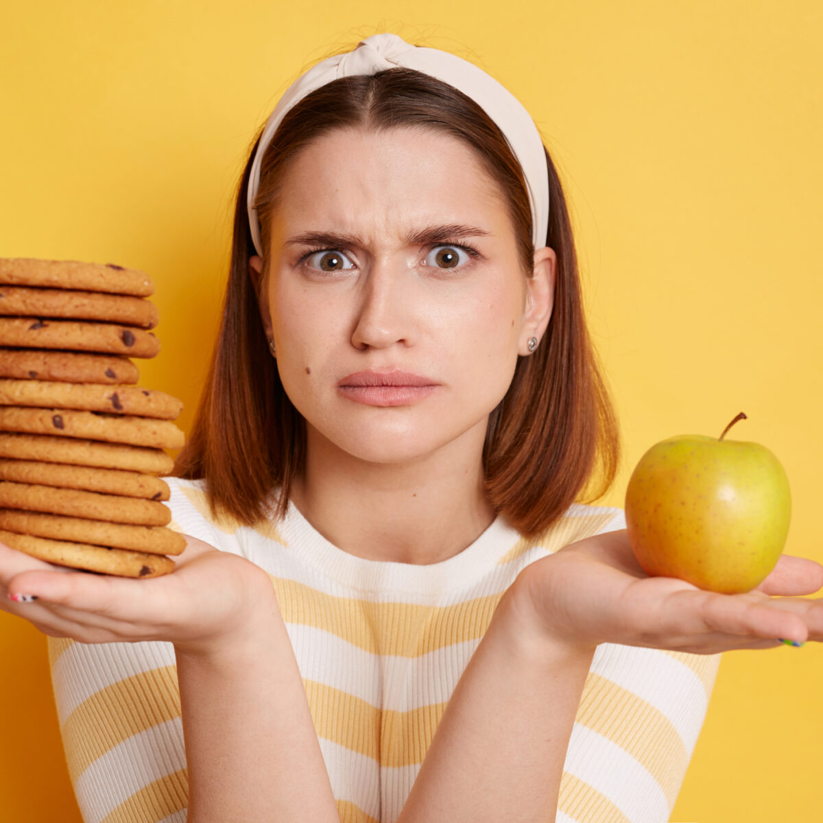 Confused woman, binge eating confusion, diet, cookies, apple