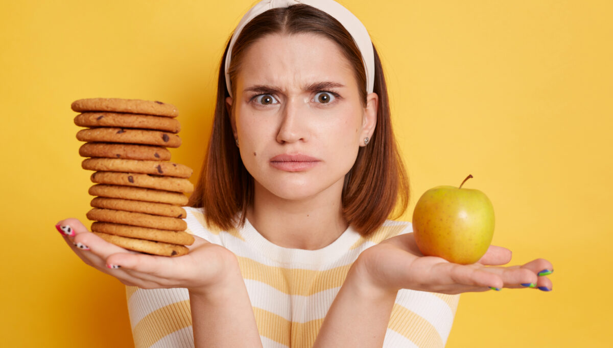 Confused woman, binge eating confusion, diet, cookies, apple