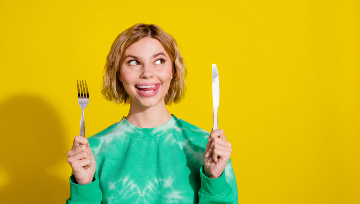 Photo of girl wear tie dye sweatshirt rising kitchen utencils looking empty space isolated yellow color background.