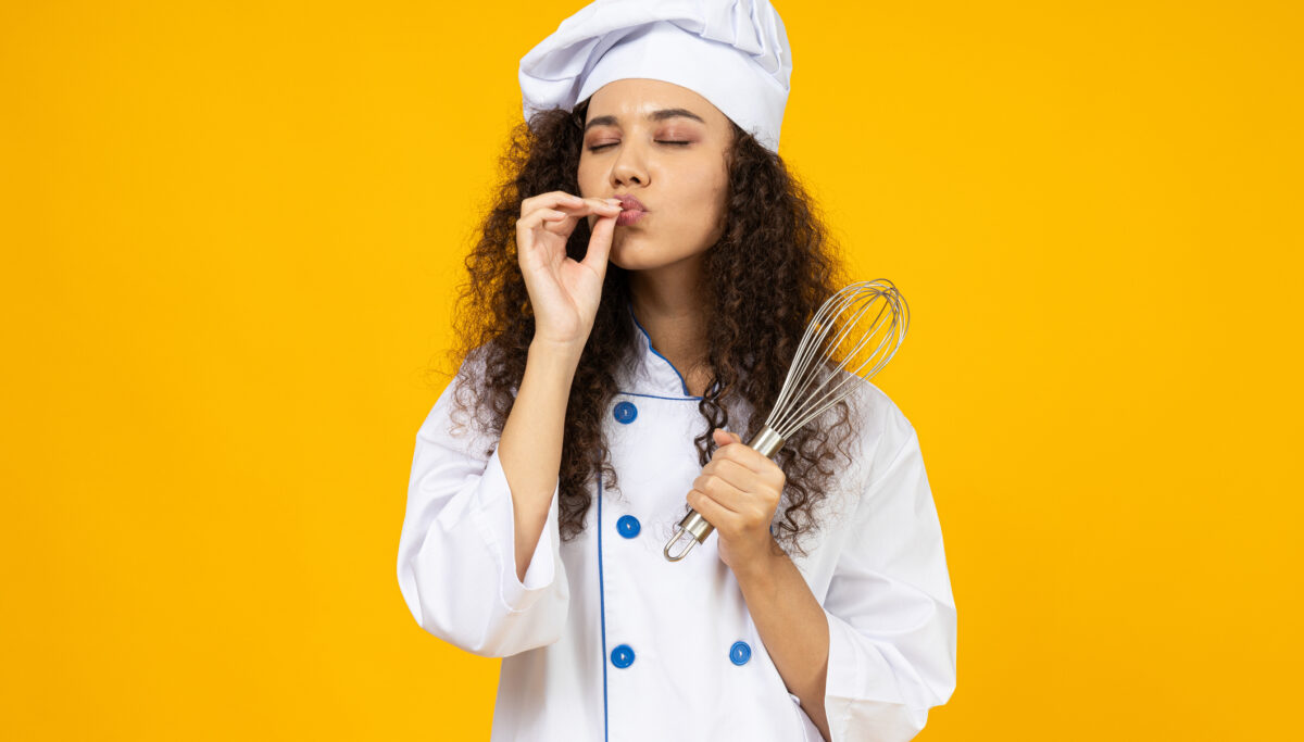 Young woman in chefs hat, meal prep concept, mum in the kitchen, isolated yellow background