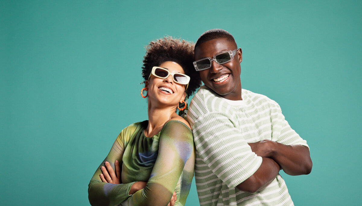 African man and woman, couple, laughing, happy and confident on green-blue background