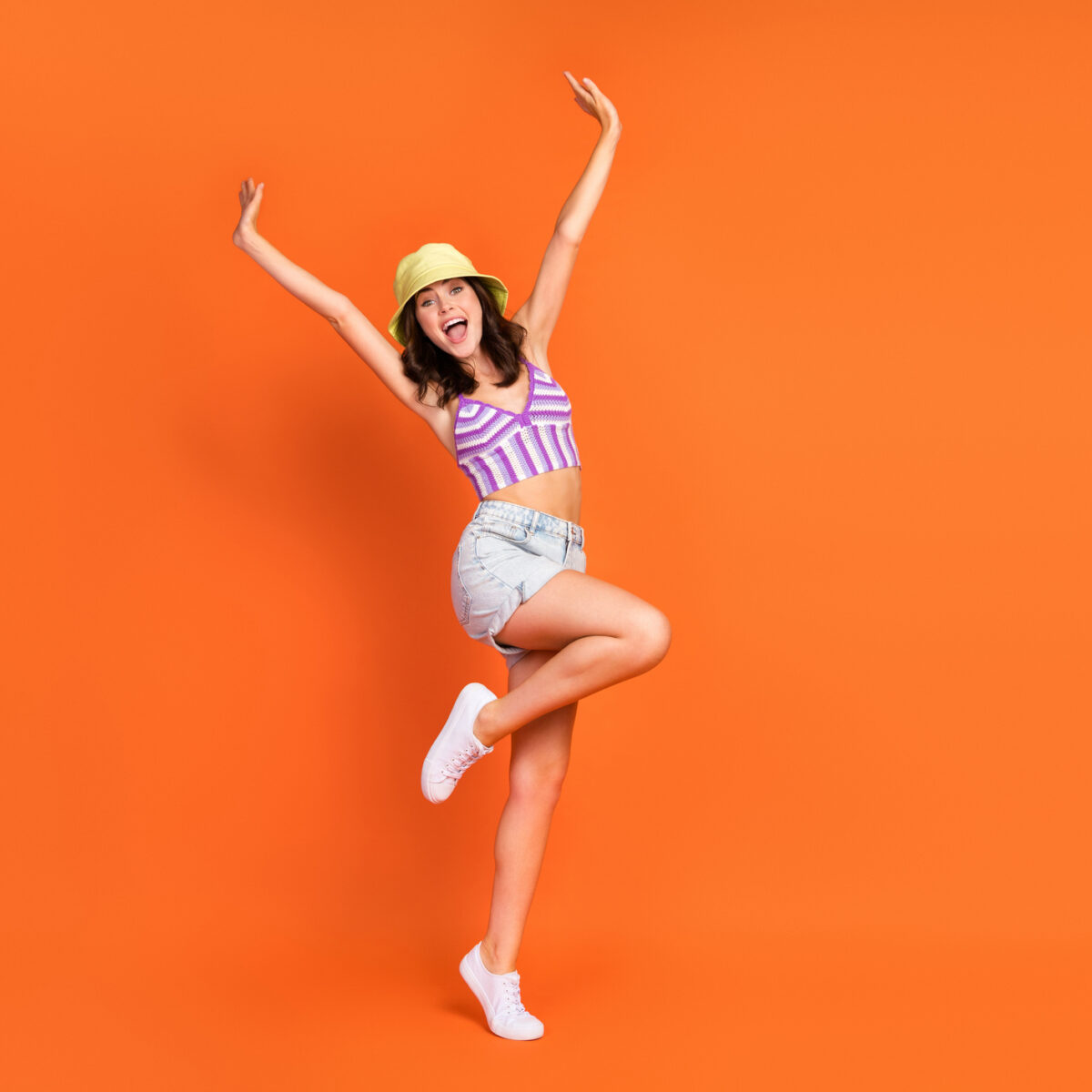 Summer fun, energy, photo of excited pretty lady purple swimwear having fun rising hands arms isolated orange color background.